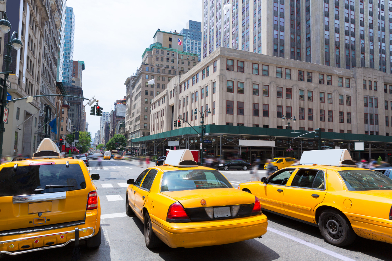 a taxi cab driving down a busy city street